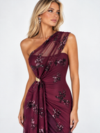 Vestido de invitada asimétrico burdeos de tul y lentejuelas con tirante cruzado y detalle en la cintura.